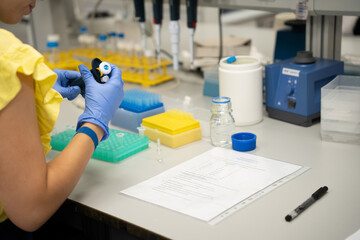 Mujer realizando an&aacute;lisis cl&iacute;nicos en laboratorio u hospital. Chica cin probetas en laboratorio luminoso.