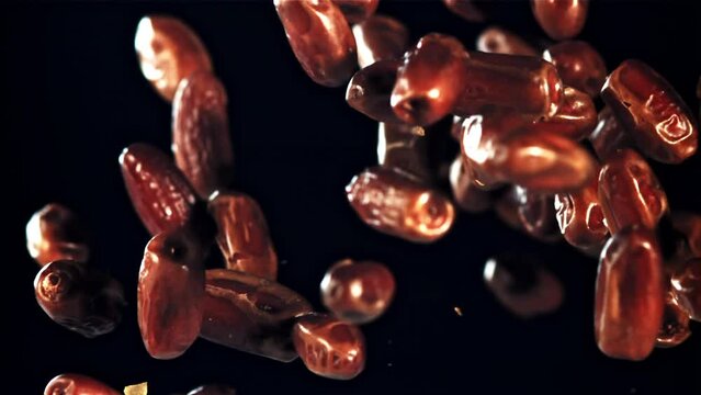 Dates rise up and rotate in flight. On a black background. Filmed on a high-speed camera at 1000 fps.