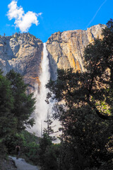 Vertical shot of Upper Yosemite Fall on a beautiful sunny summer day, Epic waterfall under blue sky in Yosemite National Park, California, USA. Natural wonders of the world.