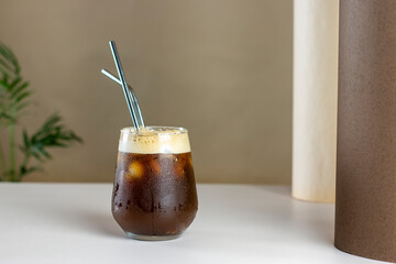 Iced coffee. Coffee cold brew drink cocktail with ice cube and straw on abstract background. Summer refreshing drink concept.