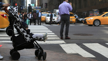 Little beautiful boy in a stroller on the New York street