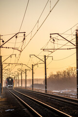 Train on the railway , winter railway , sunrise over the train and rails . 