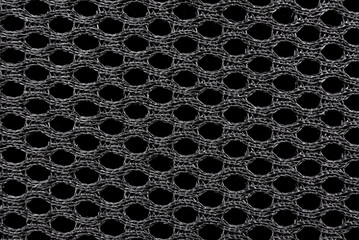 Texture of black material with mesh structure. Background from fabric in with small circles