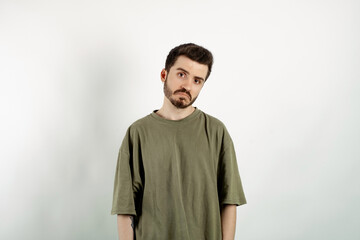 Fototapeta premium Handsome caucasian man wearing khaki t-shirt posing isolated over white background crying wipes tears losing his job. I don't know.