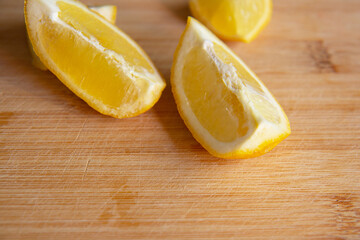 Two slices of ripe juicy lemon on a wooden board on a dark background