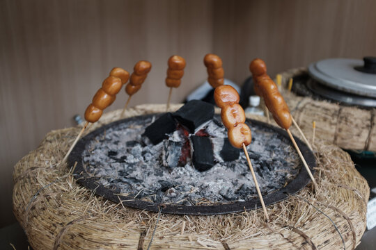 The Japanese treat dango staying warm on skewers over charcoal