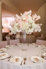 festive wedding decoration. Beautiful fresh white and pink flowers in glass vase on dining table on wedding day. High quality photo