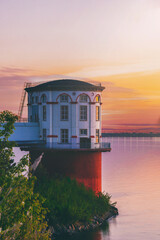 old lighthouse on the river on background of sunset beautiful sky