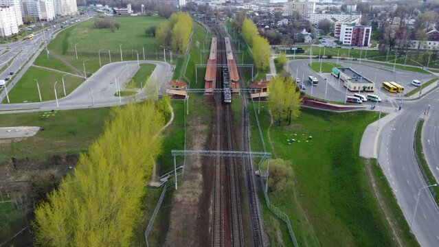 A modern train travels through the city from station to station. A sleeping area of one of the capitals of Minsk. High speed. Flying on a drone.