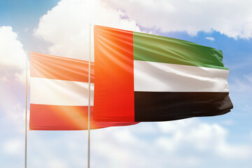 Sunny blue sky and flags of united arab emirates and austria