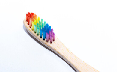 Toothbrush in rainbow colors. Ecological everyday objects. Wooden toothbrush.