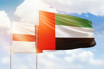 Sunny blue sky and flags of united arab emirates and england