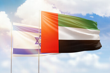 Sunny blue sky and flags of united arab emirates and israel