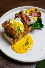 Bruschetta with parma ham and Egg Benedict. Classic Eggs Benedict with bacon, hollandaise sauce, English breakfast with tasty toasts