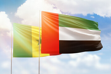 Sunny blue sky and flags of united arab emirates and senegal