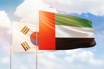 Sunny blue sky and flags of united arab emirates and south korea