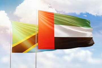 Sunny blue sky and flags of united arab emirates and tanzania