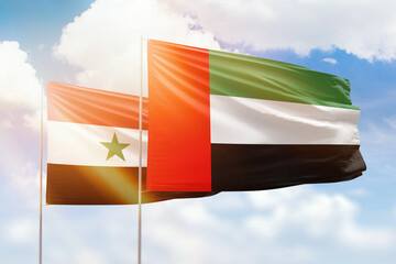 Sunny blue sky and flags of united arab emirates and syria