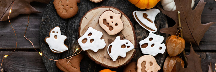 Homemade halloween holiday treats for kids. Gingerbread cookies on wooden board, decorated with...