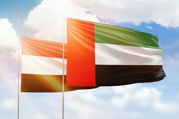 Sunny blue sky and flags of united arab emirates and yemen