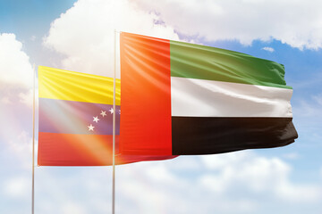 Sunny blue sky and flags of united arab emirates and venezuela