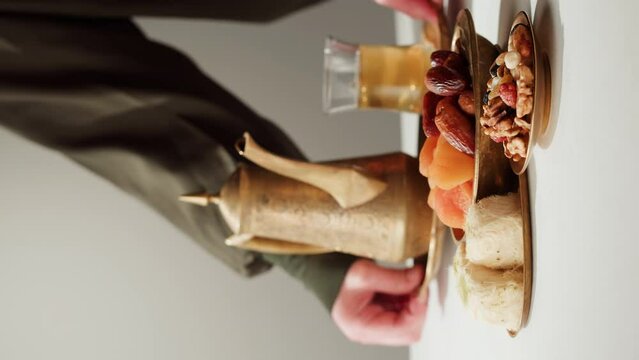 Vertical video of turkish tea and sweets, hot drink in traditional armudu glass close-up. National islamic pastry, treats.