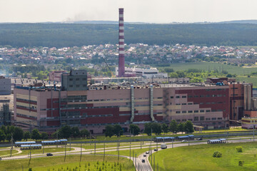 ariel panoramic view of city and skyscrapers with a huge factory with smoking chimneys in the...