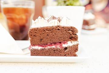 Japanese chocolate cheesecake with raspberry jam and whipped cream on top, side view