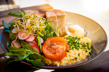 Scrambled Tofu as egg replacement with tomato, salad, radish and bread and plant-based butter