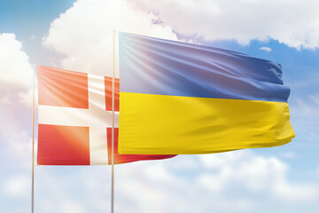 Sunny blue sky and flags of ukraine and denmark