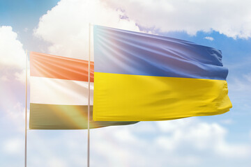 Sunny blue sky and flags of ukraine and hungary