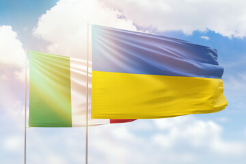 Sunny blue sky and flags of ukraine and italy