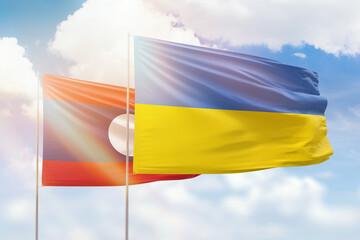 Sunny blue sky and flags of ukraine and laos