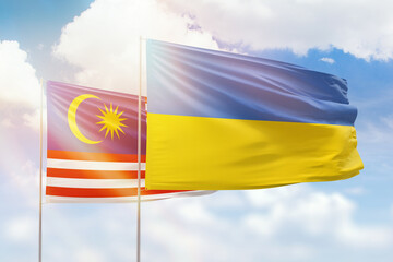 Sunny blue sky and flags of ukraine and malaysia