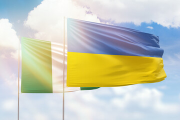 Sunny blue sky and flags of ukraine and nigeria