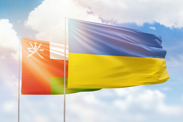 Sunny blue sky and flags of ukraine and oman
