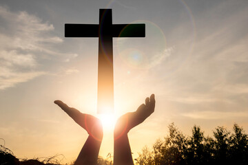 A man show hands and cross  with sunset.he is so calm hope,respect,spiritual , crucifix,religion...