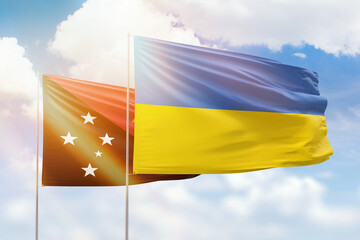 Sunny blue sky and flags of ukraine and papua new guinea
