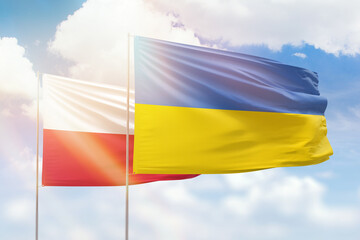 Sunny blue sky and flags of ukraine and poland