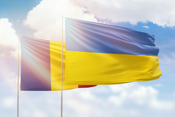 Sunny blue sky and flags of ukraine and romania