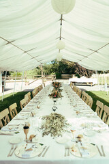 Long table set with candles, flowers, and table runner. Wedding table