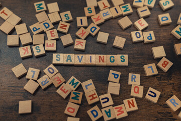 Conceptual financial photo. The word savings made out of neat little colourful square wooden puzzles. . High quality photo