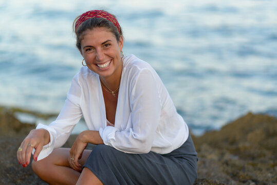 Young Woman On Vacation Happy Sitting On The Beach