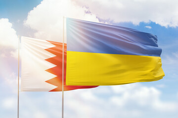 Sunny blue sky and flags of ukraine and bahrain