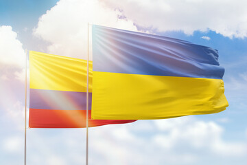 Sunny blue sky and flags of ukraine and colombia