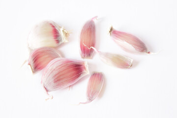 a few cloves of garlic lie on a white background