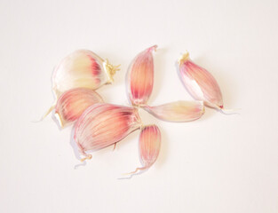a few cloves of garlic lie on a white background