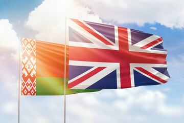 Sunny blue sky and flags of united kingdom and belarus