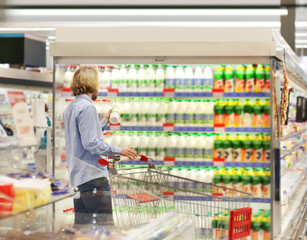 Man choosing frozen food from a supermarket freezer... choosing a dairy products at supermarket,...