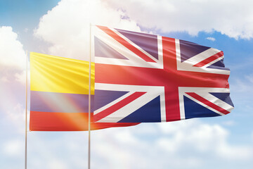 Sunny blue sky and flags of united kingdom and colombia